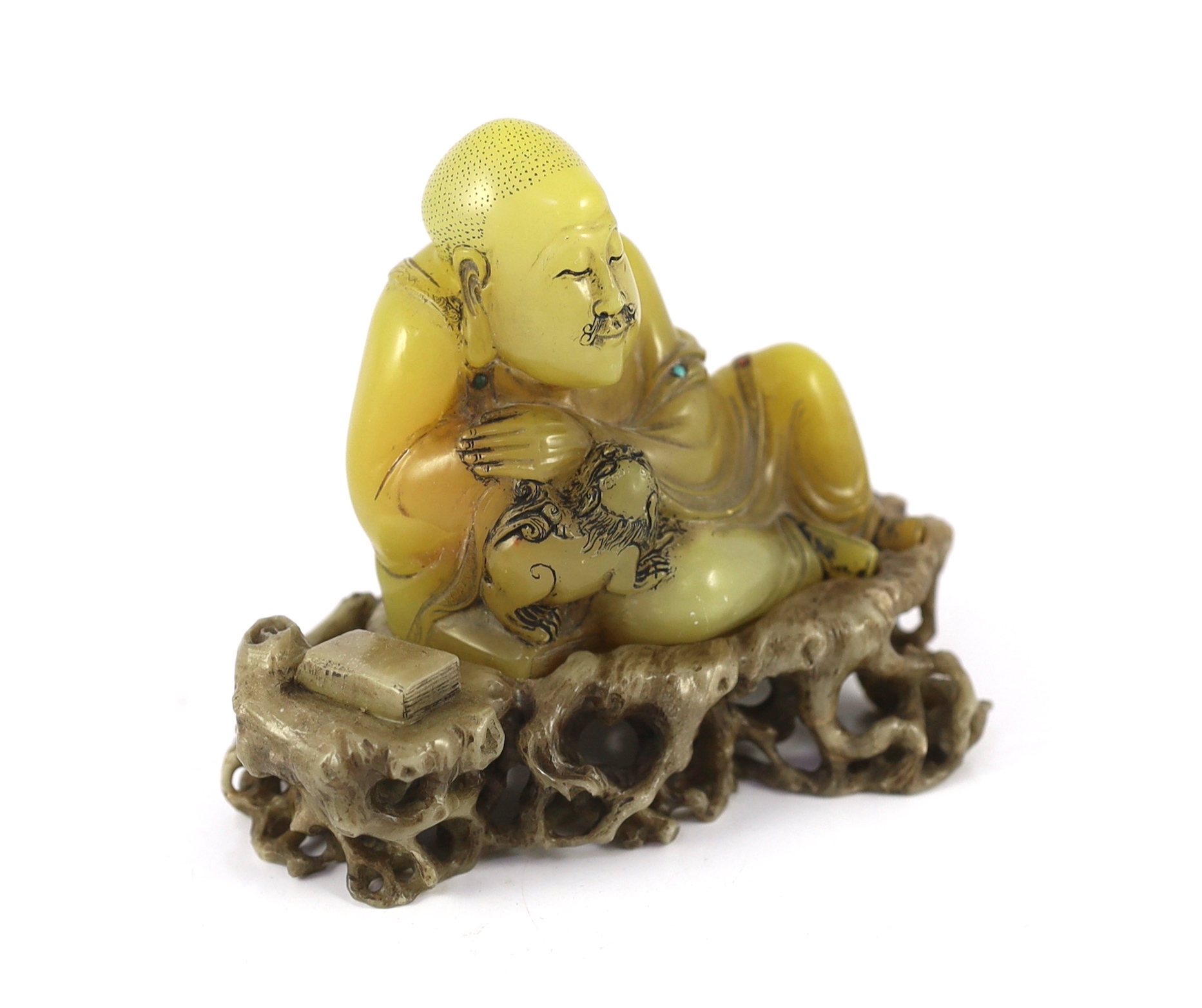 A Chinese soapstone seated group of a luohan and a lion-dog, on a soapstone stand, 18th century